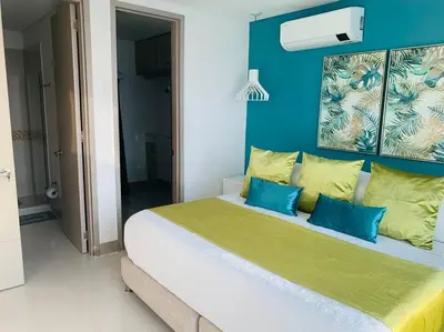 a bedroom with a large bed with blue walls at Apartament Bocagrande Palmetto Beach Front 3204 in Cartagena de Indias