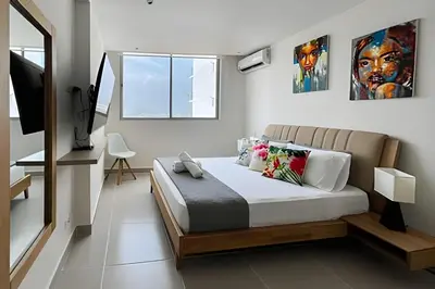 a bedroom with a king sized bed and a television at Apartamento 2 dormitorios Morros Vistas. Piscina in Cartagena de Indias