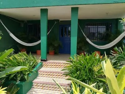 a house with a blue door and some plants at Hotelito La Aventura, AC private WC rooms near the old town, no tax in Cartagena de Indias