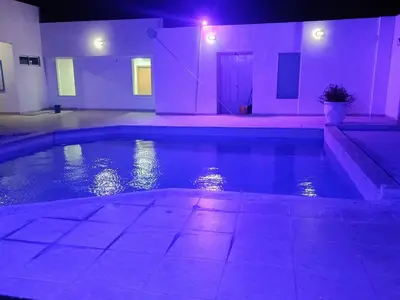a swimming pool in a house with purple lights at Hotel Doral Barranquilla in Barranquilla