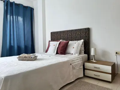 a bedroom with a large bed with a blue curtain at Northwest Hostings 201 in Cartagena de Indias