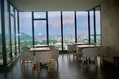 a restaurant with tables and chairs in a room with windows at Apartamento nuevo en cartagena en el cabrero in Cartagena de Indias