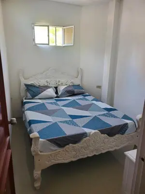 a blue and white bed in a room with a window at Apartamentos y habitaciones cerca a marbella in Cartagena de Indias