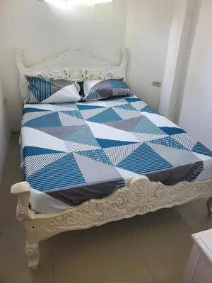 a bed with a blue and white quilt on it at Apartamentos y habitaciones cerca a marbella in Cartagena de Indias
