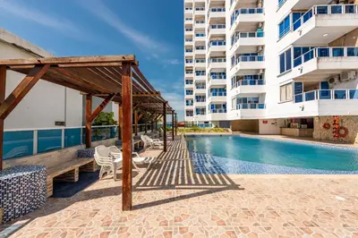 a swimming pool next to a tall building at Bienesweb Apartamentos Conquistador Premium in Cartagena de Indias