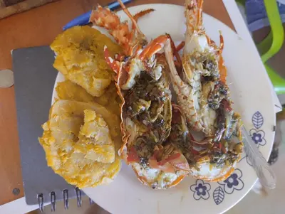 a plate of food with seafood and chips and a fork at HOSTAL LAMAR BARU dónde Gertrudis in Playa Blanca