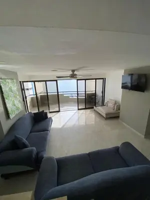 a living room with a blue couch and a tv at APTO DUPLEX MARINA DEL REY CARTAGENA in Cartagena de Indias