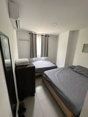 a bedroom with two beds and a television in it at Apto PB Palmar de los vientos in San Bernardo del Viento