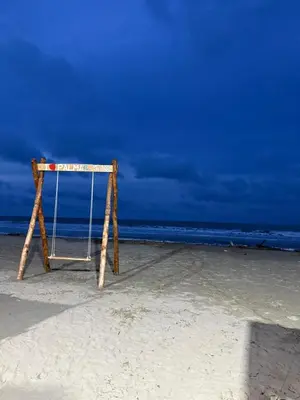 a swing on a beach with the ocean in the background at Apto PB Palmar de los vientos in San Bernardo del Viento