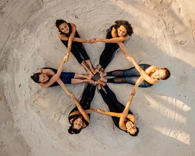 a group of people in a circle in the sand at Namaste Beach Club & Hotel in Tierra Bomba