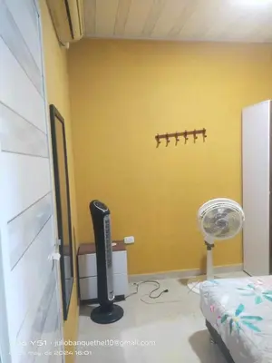 a room with a yellow wall with a heater and a fan at Casa Murillo in San Antero