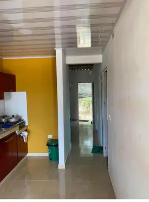 a kitchen with yellow walls and a hallway at Casa Murillo in San Antero
