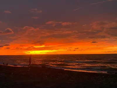 a sunset on the beach with the ocean at Cabaña El Esplendor in San Bernardo del Viento
