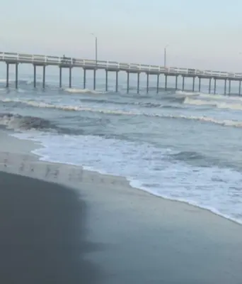 a beach with a pier in the ocean at Cabaña El Esplendor in San Bernardo del Viento