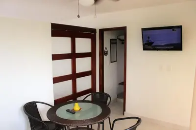 a room with a table and chairs and a tv on the wall at Villa Patry Coveñas in Coveñas