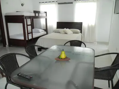 a room with a table and chairs and a bed at Villa Patry Coveñas in Coveñas