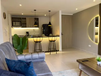 a living room with a couch and a kitchen at Lujoso apartamento cerca al Aeropuerto y Ciudad Amurallada in Cartagena de Indias