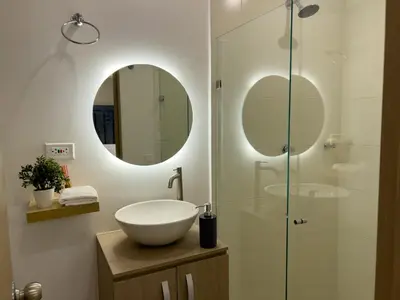 a bathroom with a sink and a glass shower at Lujoso apartamento cerca al Aeropuerto y Ciudad Amurallada in Cartagena de Indias