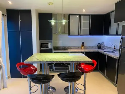 a kitchen with red stools at a kitchen island at Sunshine 503 Beautiful SeaView 2Beds2bath w AC front Beach in Cartagena de Indias