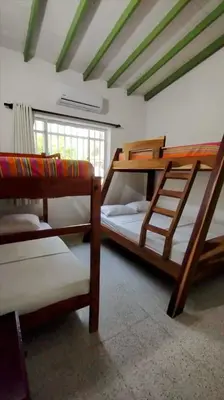a room with three bunk beds in a room at Atardeceres Coveñas - Cabañas frente al mar in Puerto Viejo