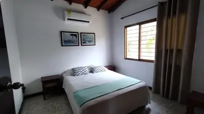 a bedroom with a bed and a window at Atardeceres Coveñas - Cabañas frente al mar in Puerto Viejo
