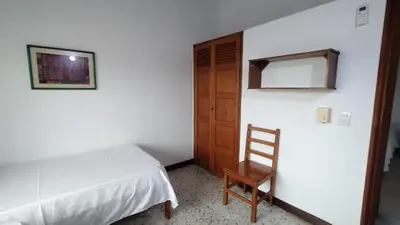a bedroom with a bed and a wooden door at Atardeceres Coveñas - Cabañas frente al mar in Puerto Viejo