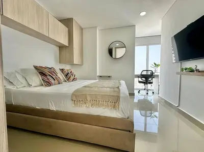 a bedroom with a large bed and a mirror at Luxury Sea View Duplex in the Heart of the City in Cartagena de Indias