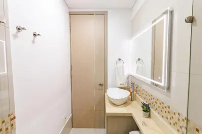 a bathroom with a sink and a toilet and a mirror at U-GO Palmetto Beach - Lujo Frente al Mar in Cartagena de Indias