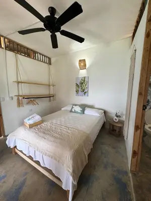 a bedroom with a bed with a ceiling fan at Cabaña Punta Coral in Rincón
