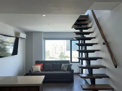 a spiral staircase in a living room with a couch at Apartamento Duplex en Barranquilla in Barranquilla