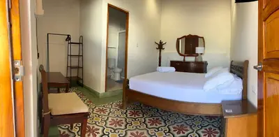 a bedroom with a bed and a mirror and a bathroom at Casa Belia in Cartagena de Indias