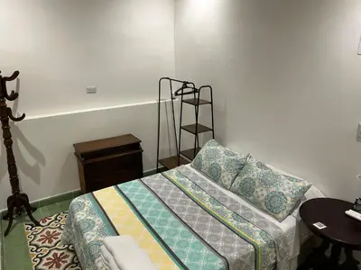 a bedroom with a bed and a chair and a table at Casa Belia in Cartagena de Indias