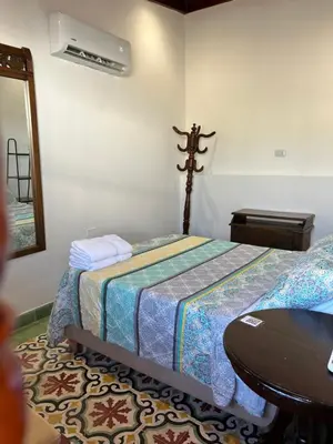 a bedroom with a bed and a table in it at Casa Belia in Cartagena de Indias
