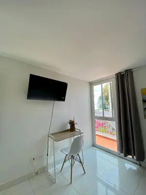 a room with a chair and a table and a window at Casa Jardin in Cartagena de Indias