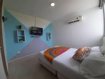 a bedroom with a bed and a tv on the wall at Apartamento familiar en Coveñas in Coveñas