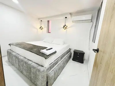 a bedroom with a bed in a white room at Apto nuevo al lado de la UNorte, 10 Min Buena vista Grav vista in Barranquilla