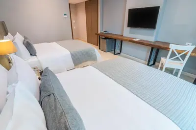 a hotel room with two beds and a flat screen tv at GHL San Lazaro Art Hotel in Cartagena de Indias