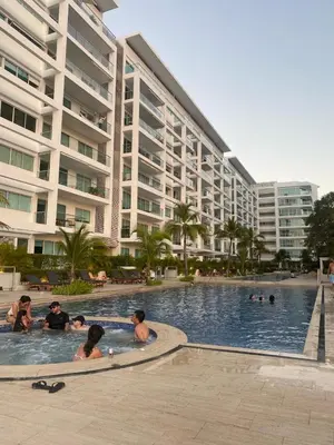 a group of people in a swimming pool next to a large building at Cartagena Apartamento en Morros en Primera Linea de PLaya in Cartagena de Indias