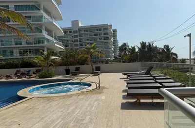 a swimming pool with lounge chairs and a building at Cartagena Apartamento en Morros en Primera Linea de PLaya in Cartagena de Indias