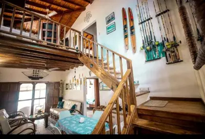 a living room with a wooden staircase and a table at ACUARELA in Trementino