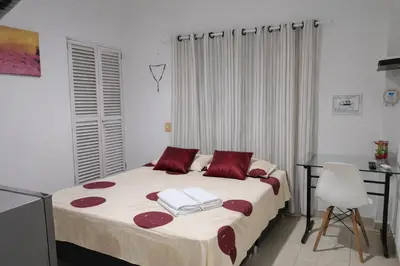 a bedroom with a bed with red pillows and a desk at Maos flats-Habitacion comfort in Cartagena de Indias