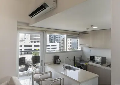 a kitchen with a counter and chairs and a balcony at Luxury Apartment In Bocagrande With Ocean View 502 in Cartagena de Indias