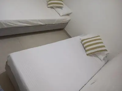 a white bed in a room with two twin beds at Hostal Catalleya in Cartagena de Indias