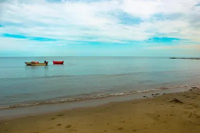 two boats sitting in the water on the beach at Apartamento Villa Carolina 102 in Coveñas