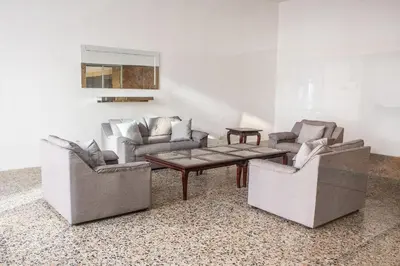 a living room with three chairs and a coffee table at Vista al Mar - 77Rentals in Cartagena de Indias