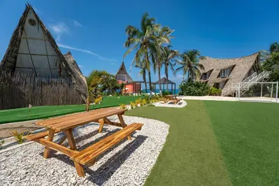 a wooden bench sitting in the grass near a house at Isla Matamba in Isla Grande