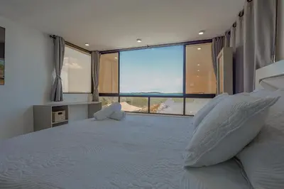 a bedroom with a large bed with a large window at Lujoso apartamento con vista al mar in Cartagena de Indias