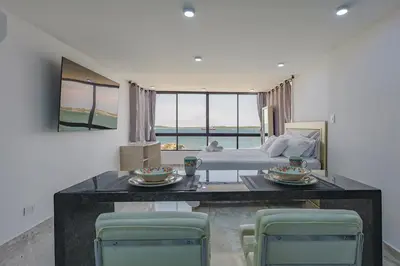 a bedroom with a bed and a table and chairs at Lujoso apartamento con vista al mar in Cartagena de Indias