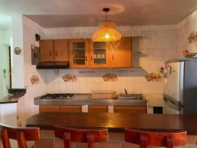 a kitchen with a wooden table and a refrigerator at Apartamento en la ciudad amurallada cerca de todo in Cartagena de Indias