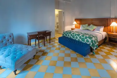a bedroom with a bed and a bench and a desk at Casa en la mejor plaza de la ciudad vieja in Cartagena de Indias